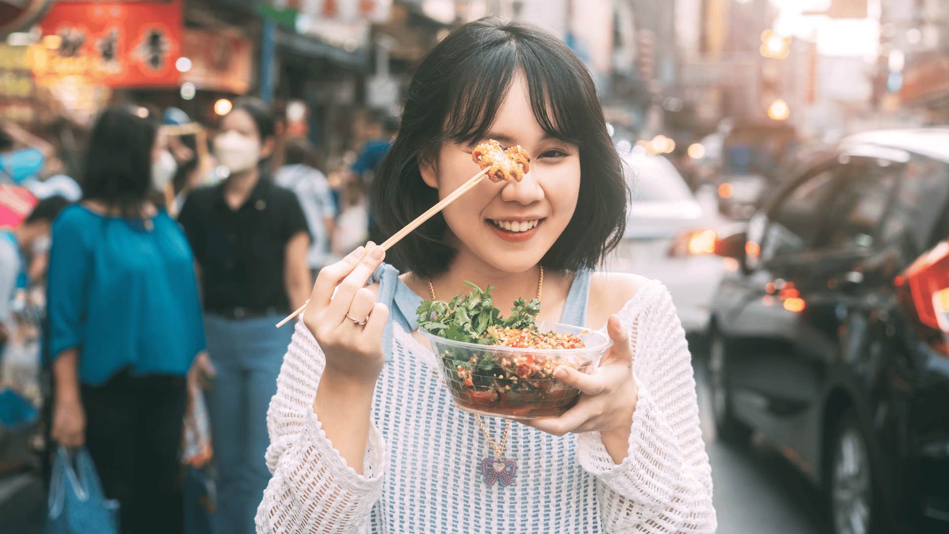 woman holding up fried squid 