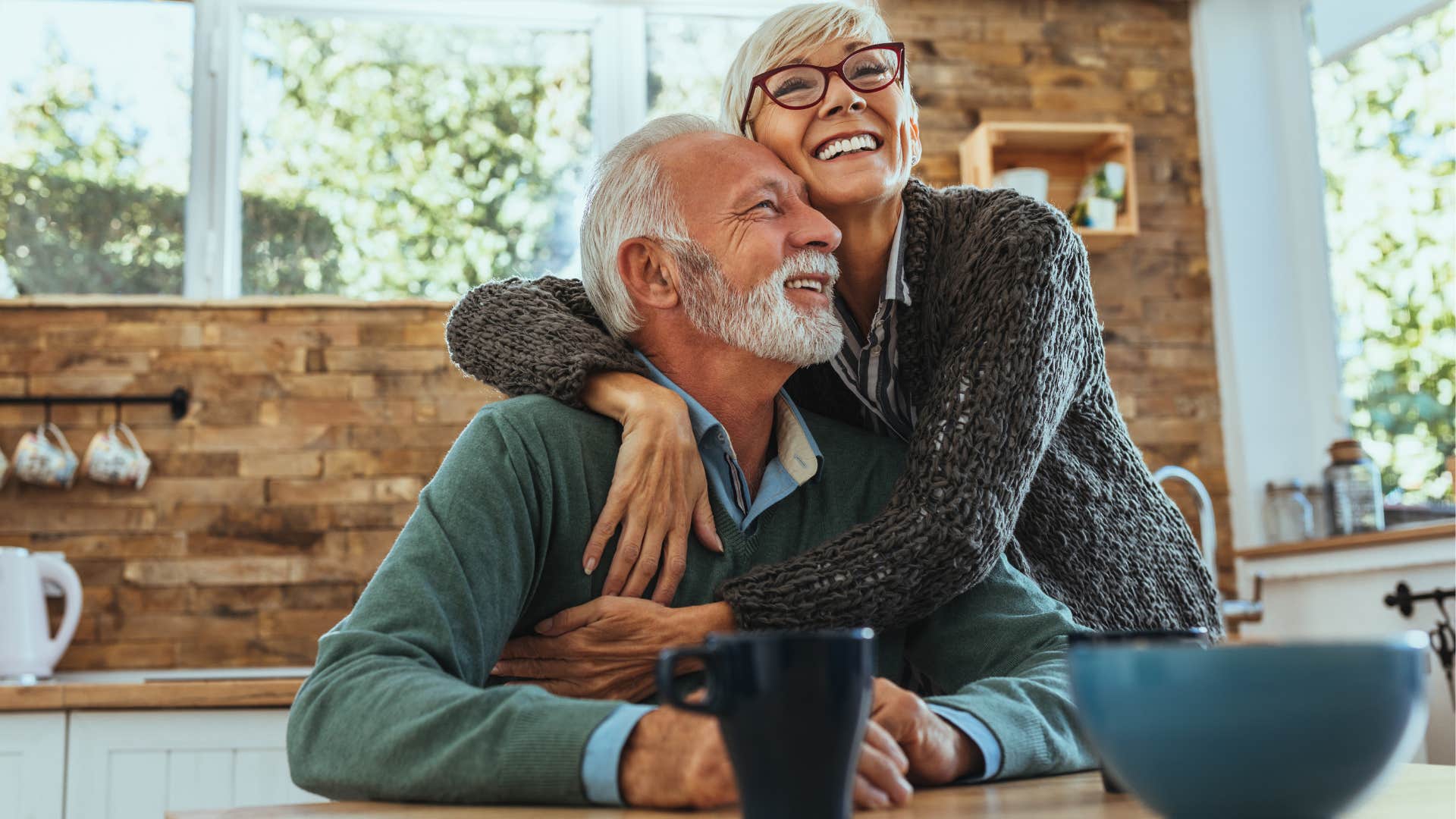 Older couple smiling and hugging each other at home