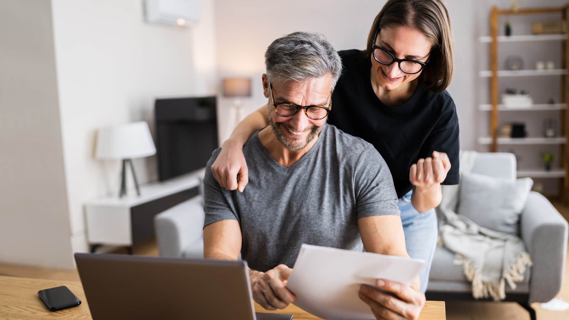 Couple smiling and doing bills together