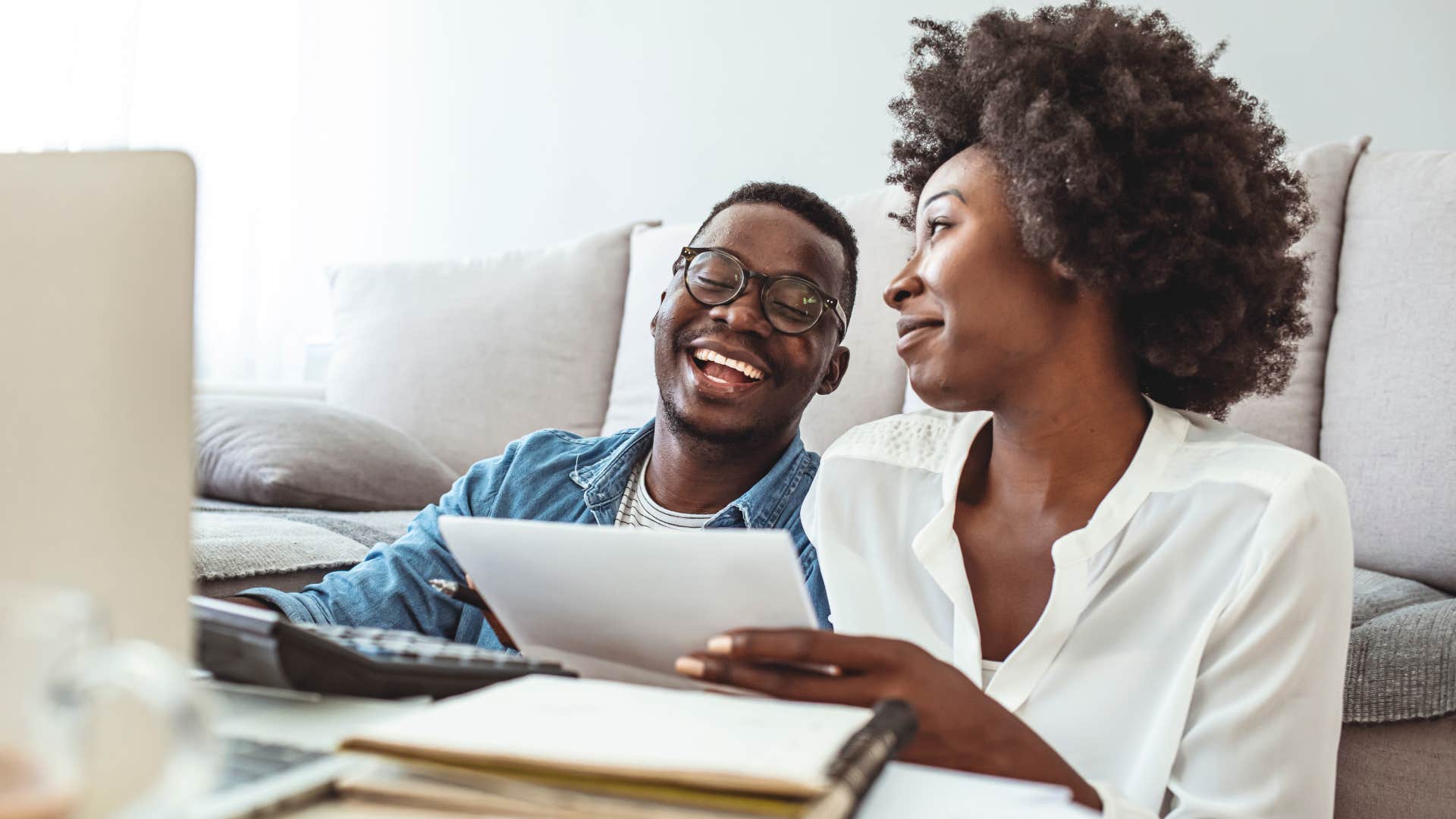 Couple smiling and looking at their laptop together