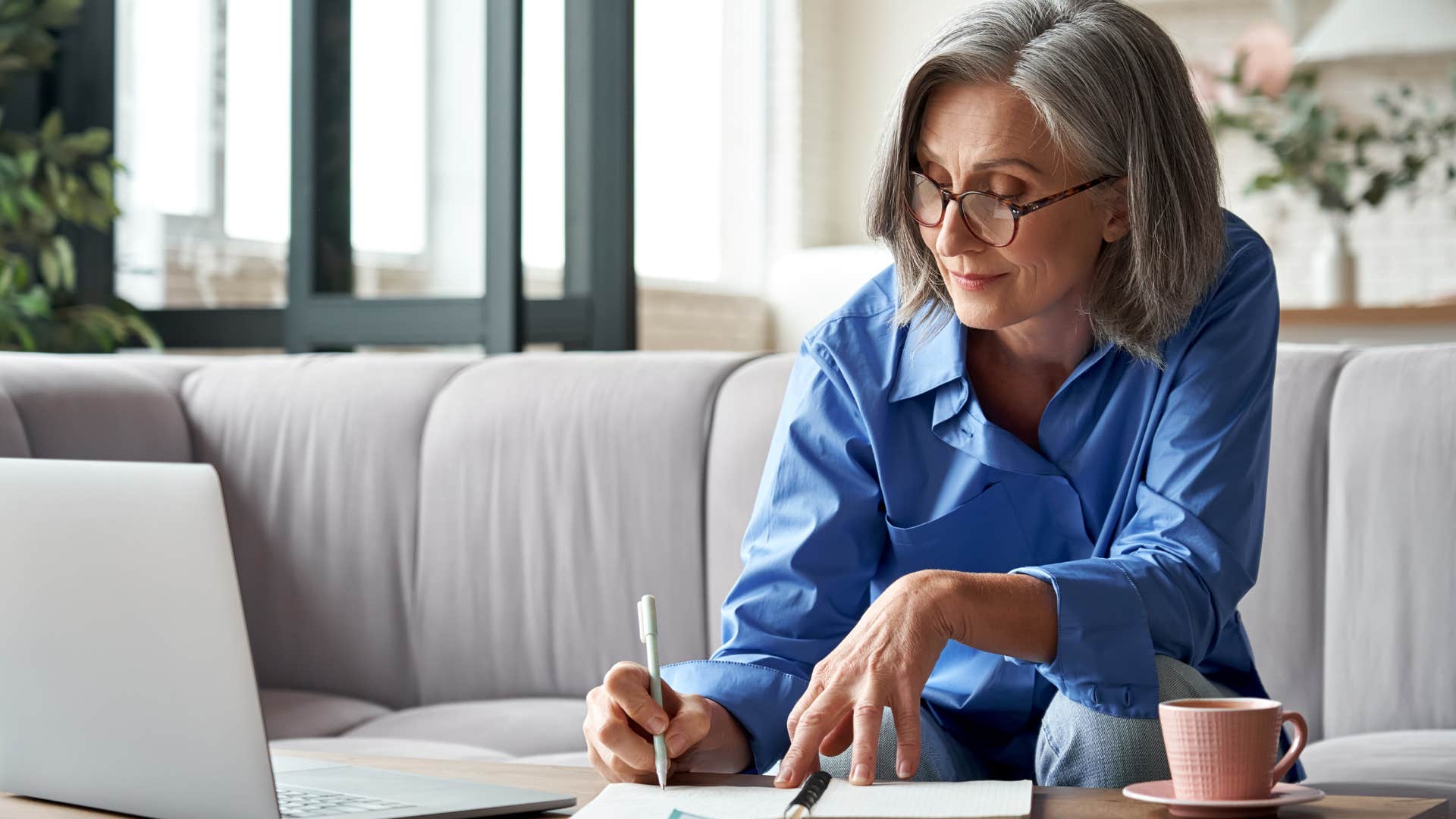 Older woman smiling and writing on a piece of paper