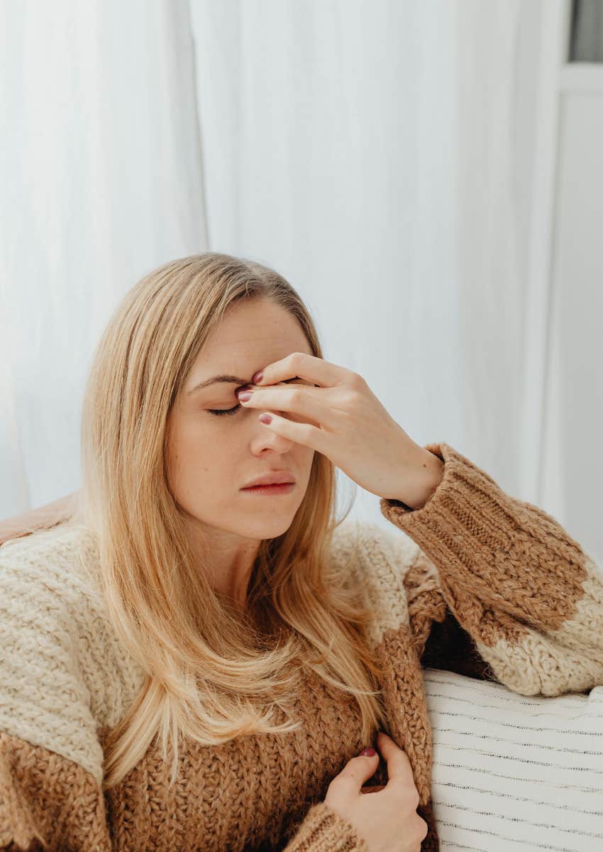 frustrated woman frowning and holding the bridge of her nose