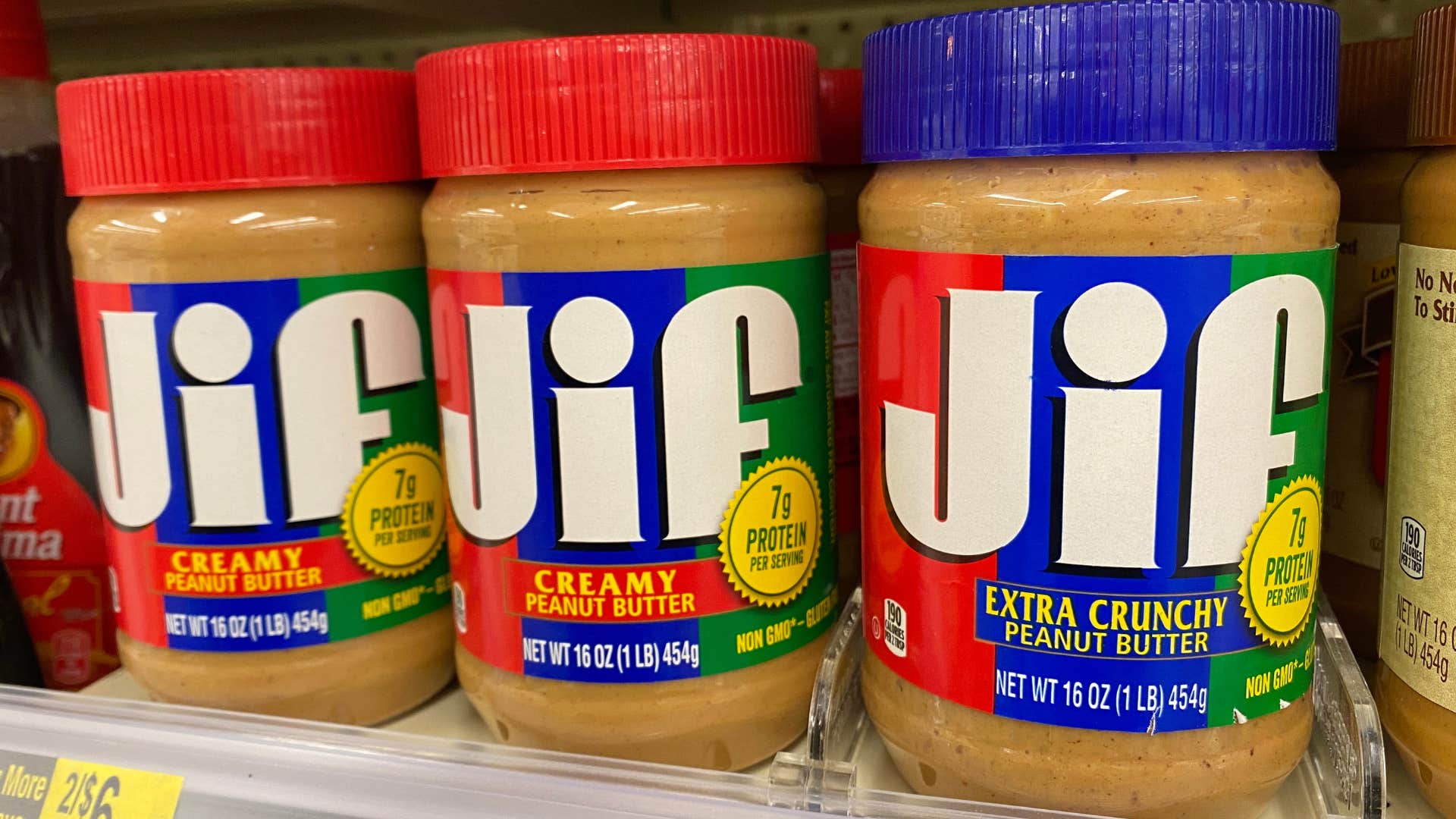 Jars of Jif peanut butter on a grocery store shelf