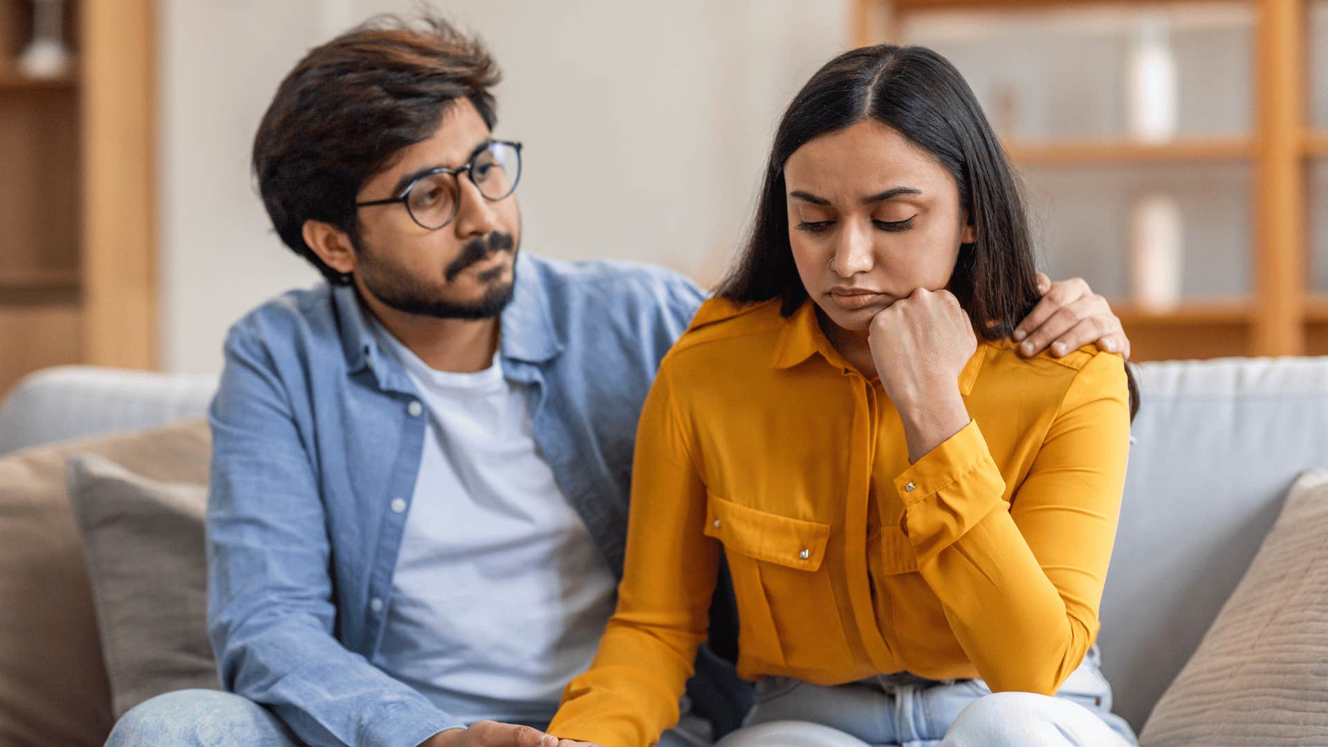 Man actively listens to woman while gently holding her