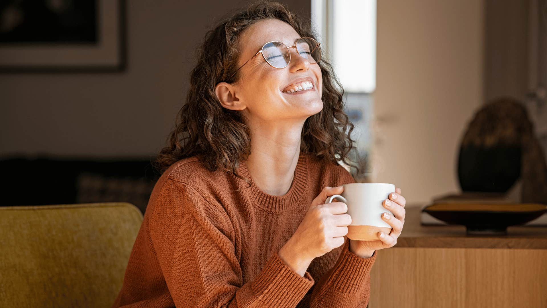 woman smiling and drinking coffee