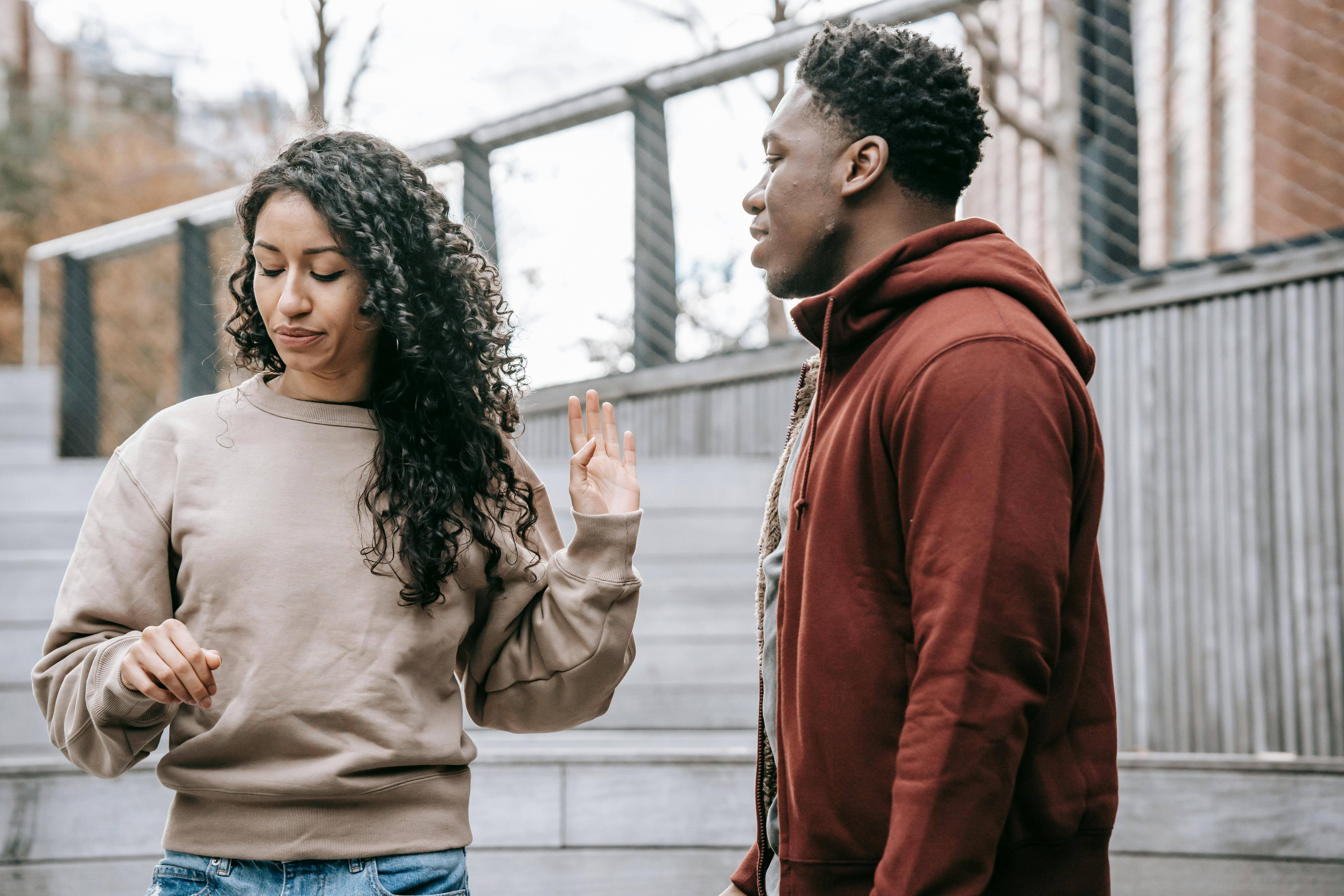 woman putting her hand up at a man