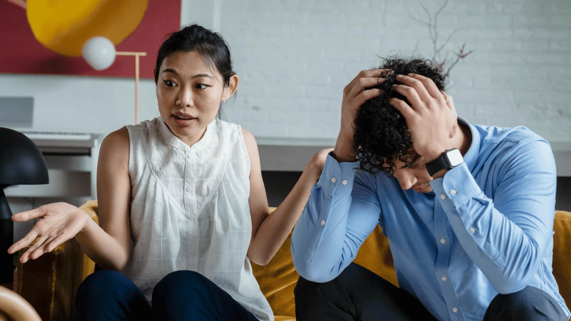 man with his hands in his hands next to woman arguing