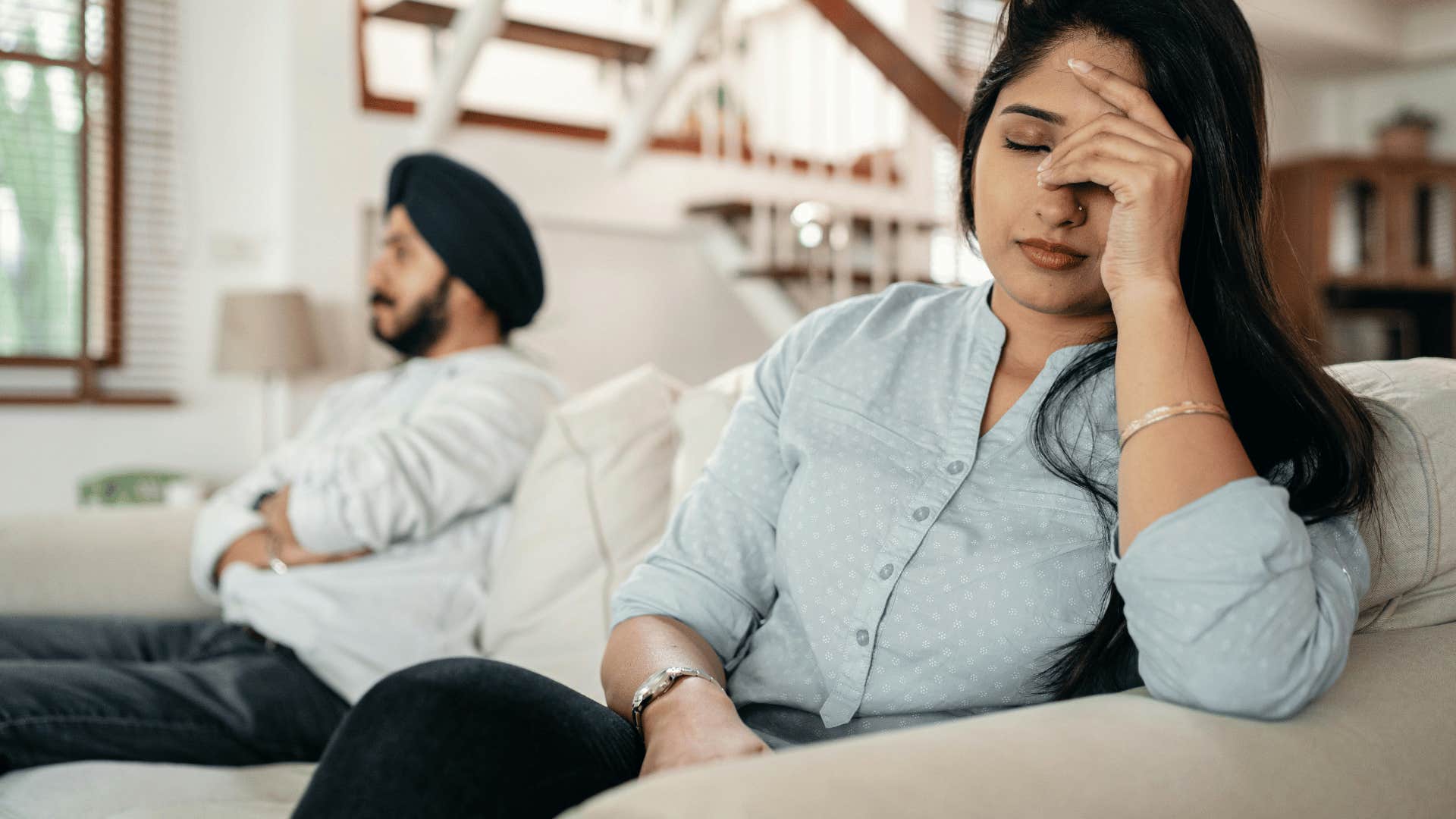 upset couple sitting on a couch