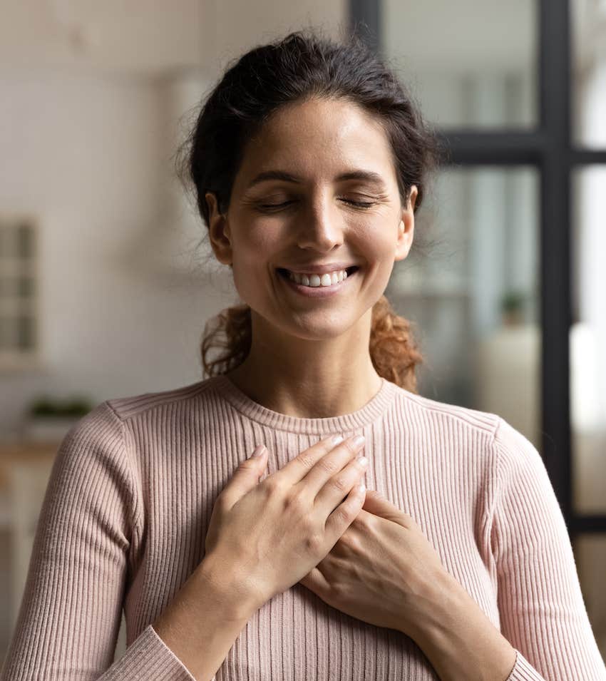 Mindful woman places hands on her heart to connect