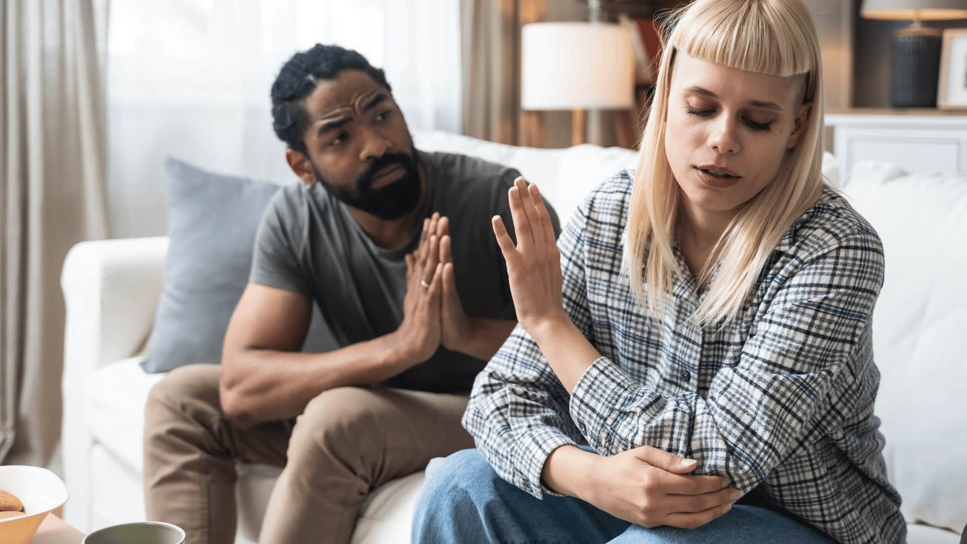 man and woman arguing on couch