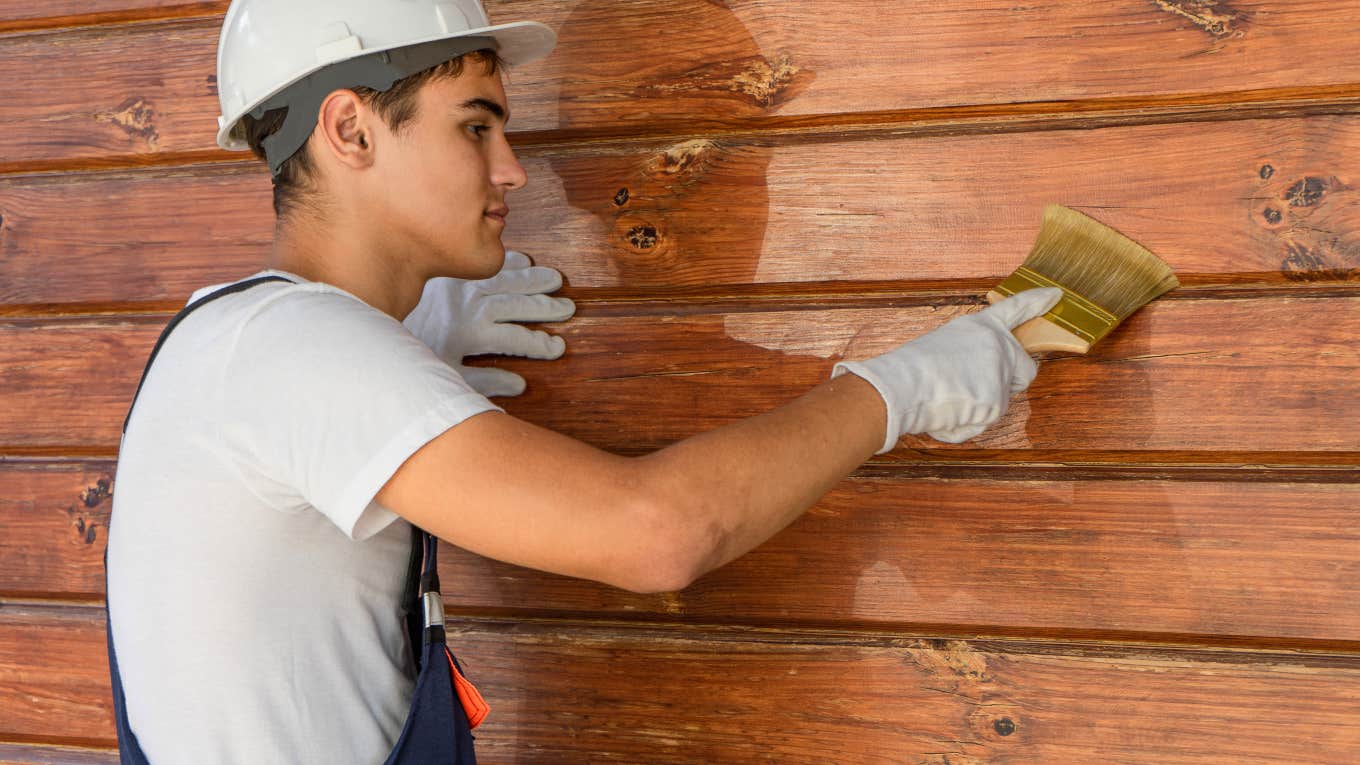 man painting exterior of a house