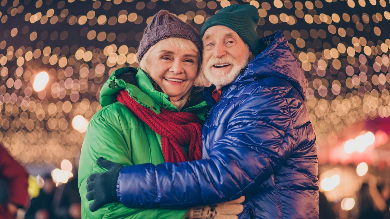 Senior couple in front of Christmas lights