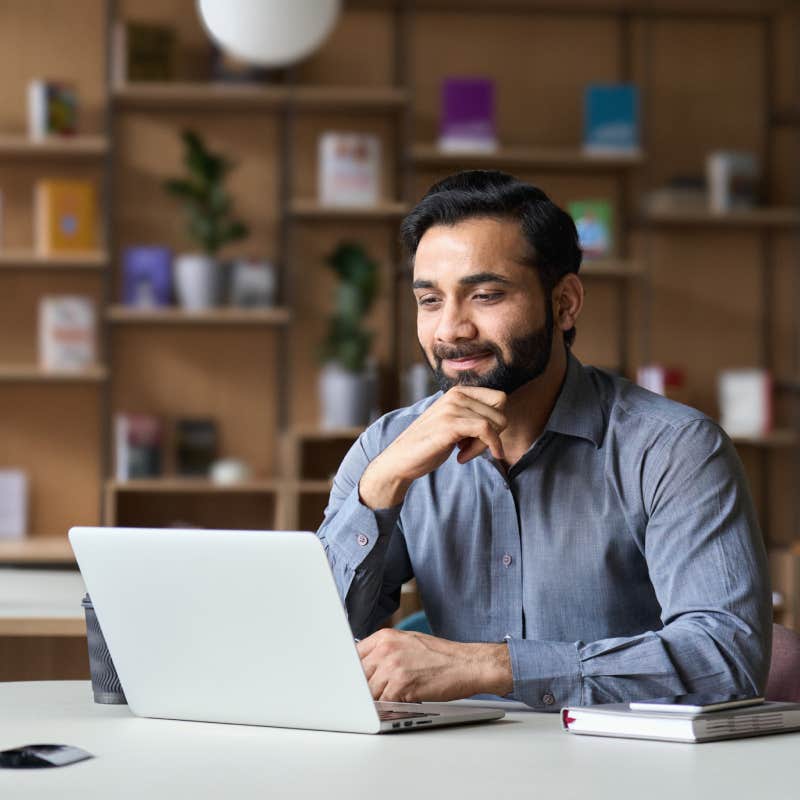 smiling businessman working on laptop