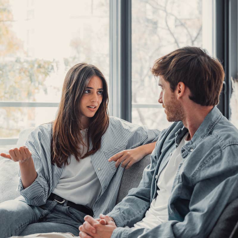 young couple having conversation on couch