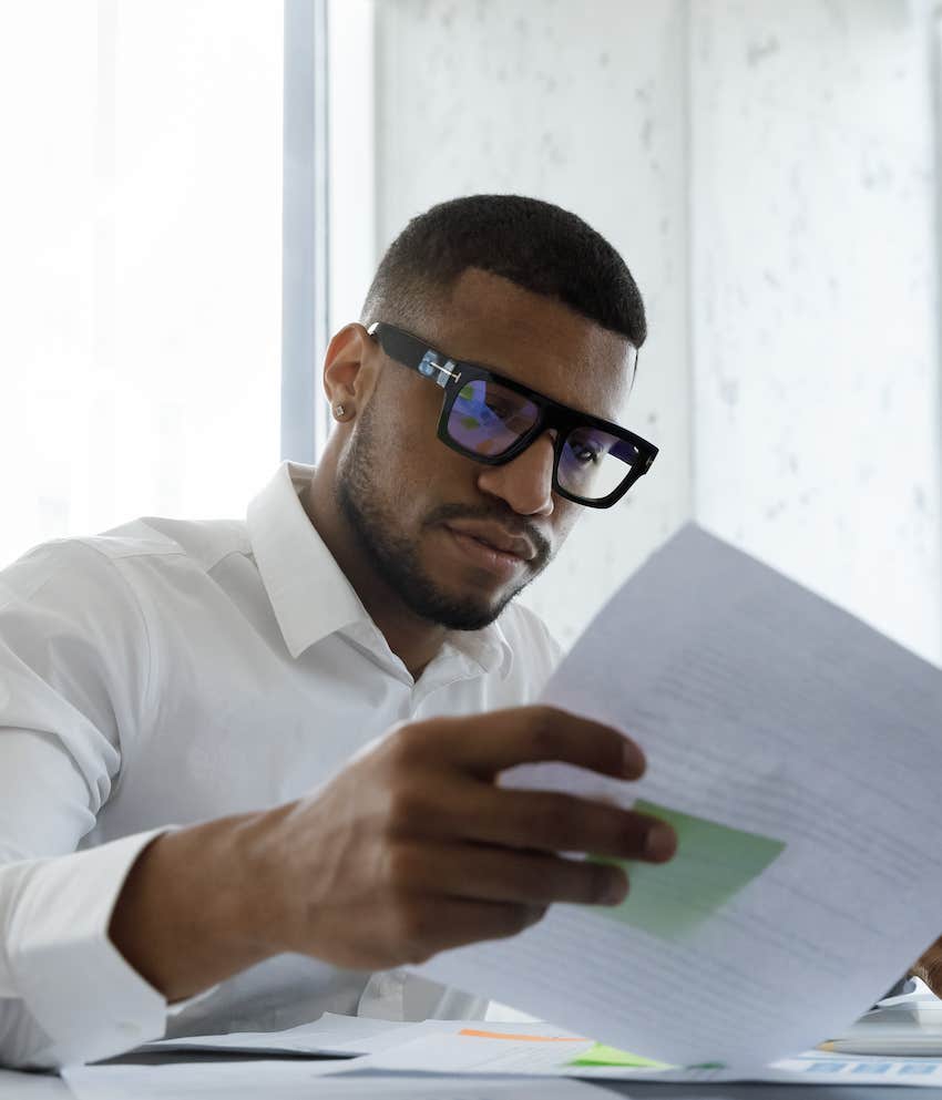 Serious man looks at paperwork to identify his leadership style