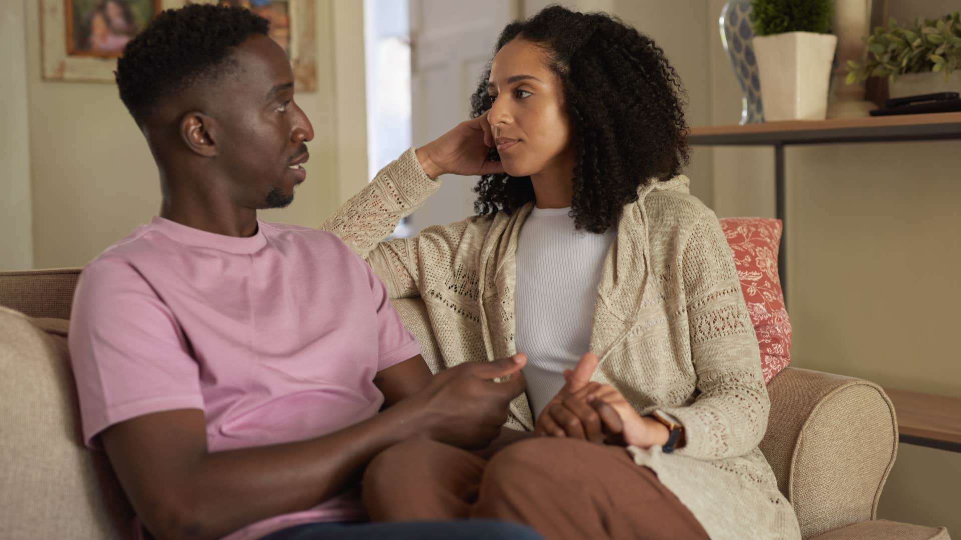 Woman having a serious conversation with her partner on the couch.