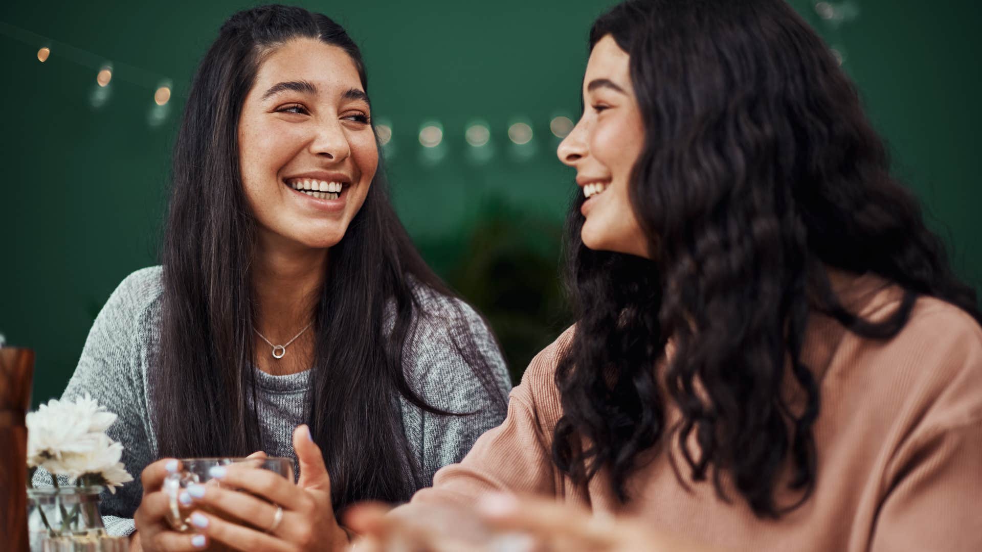 Two young women smiling and laughing together.