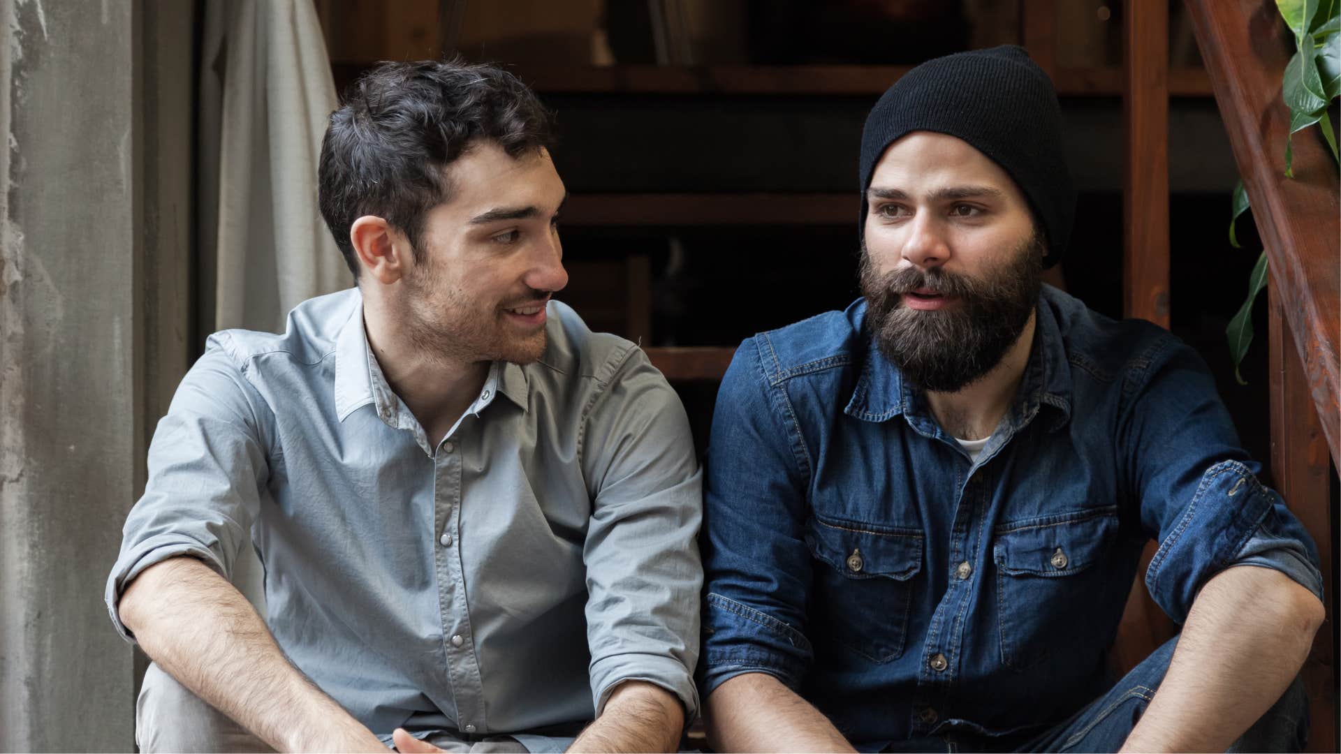 Two men smiling and talking to each other on the stairs.