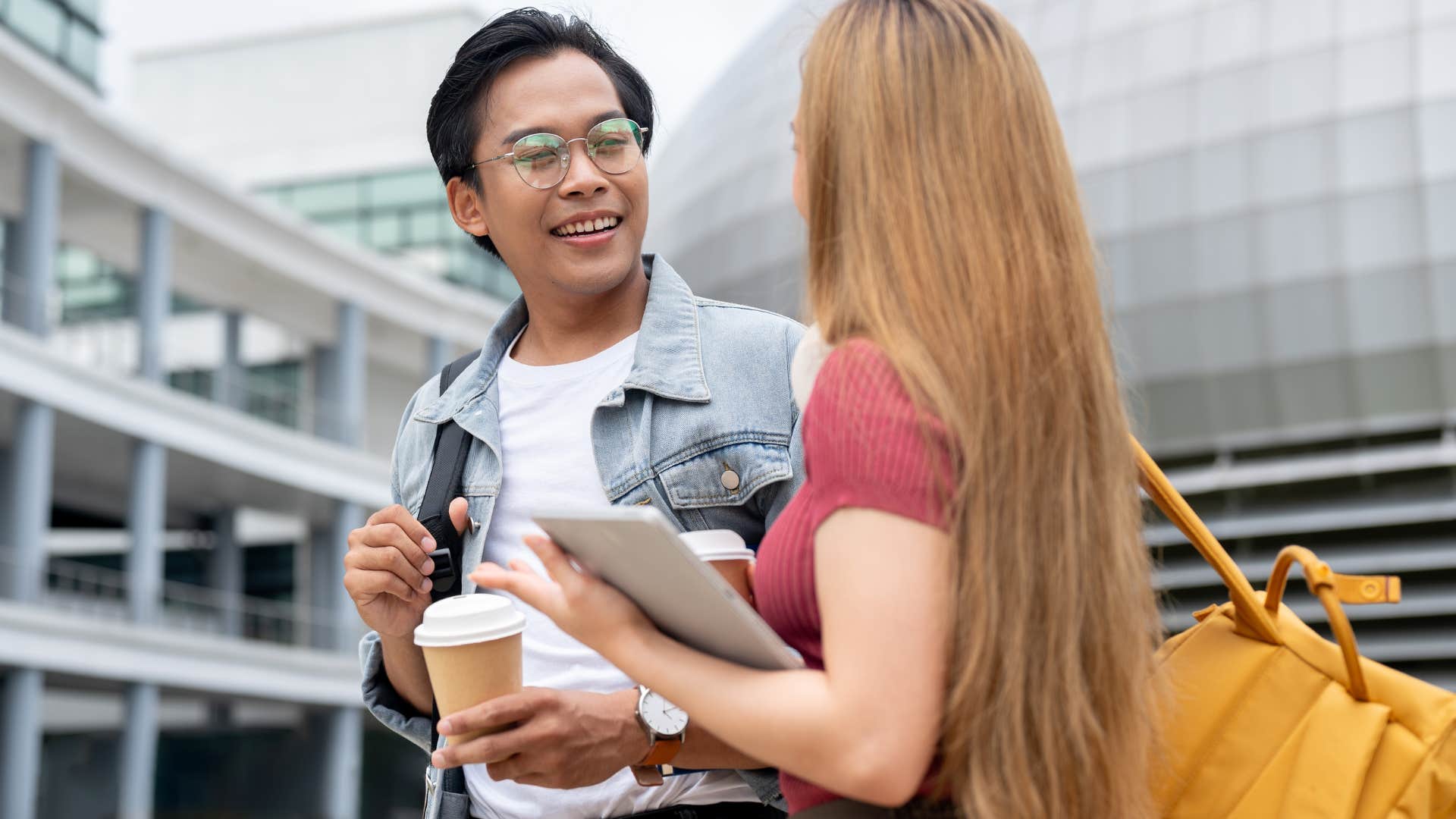 Man smiling and talking to a woman.