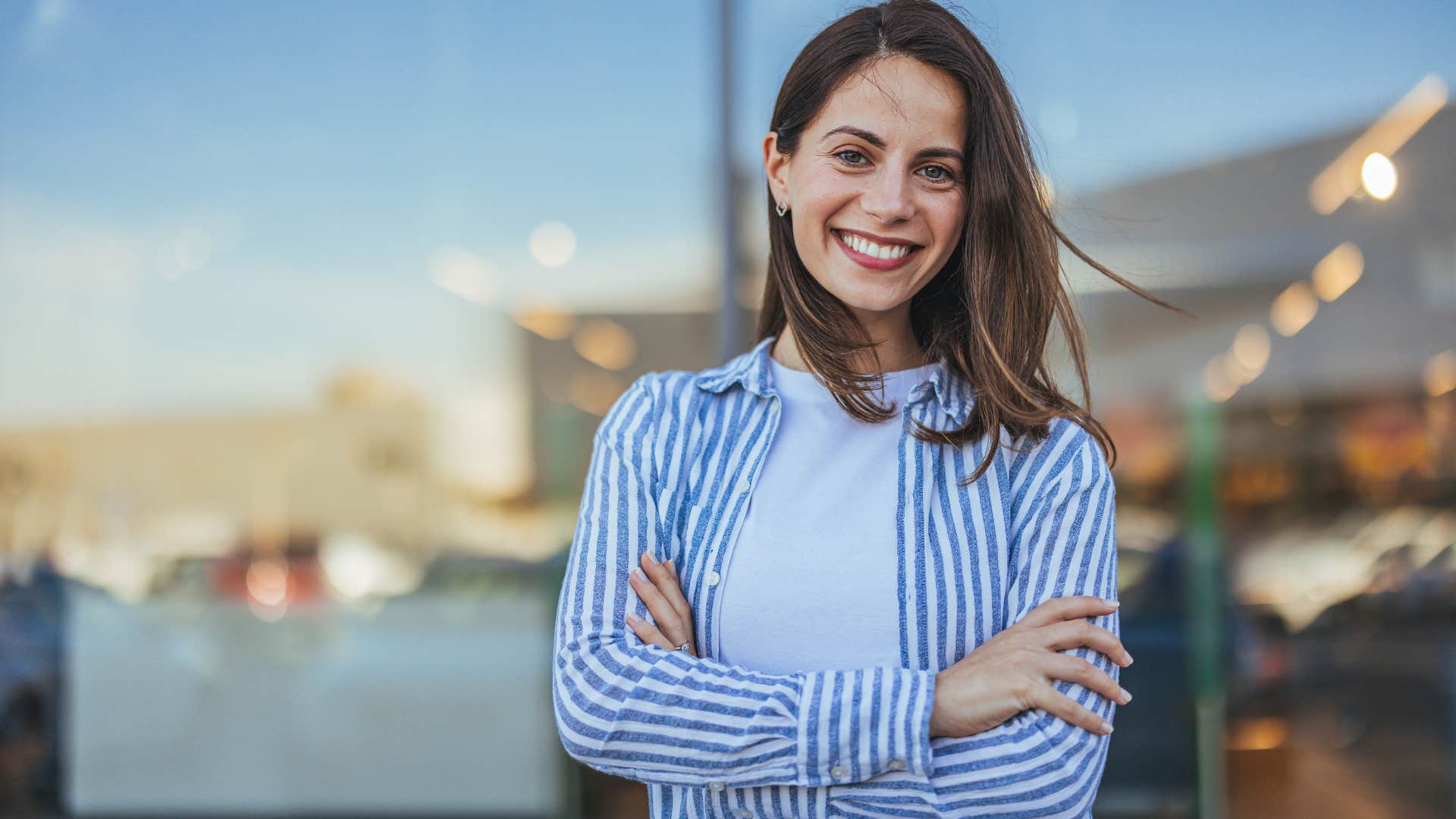 Woman smiling and crossing her arms.