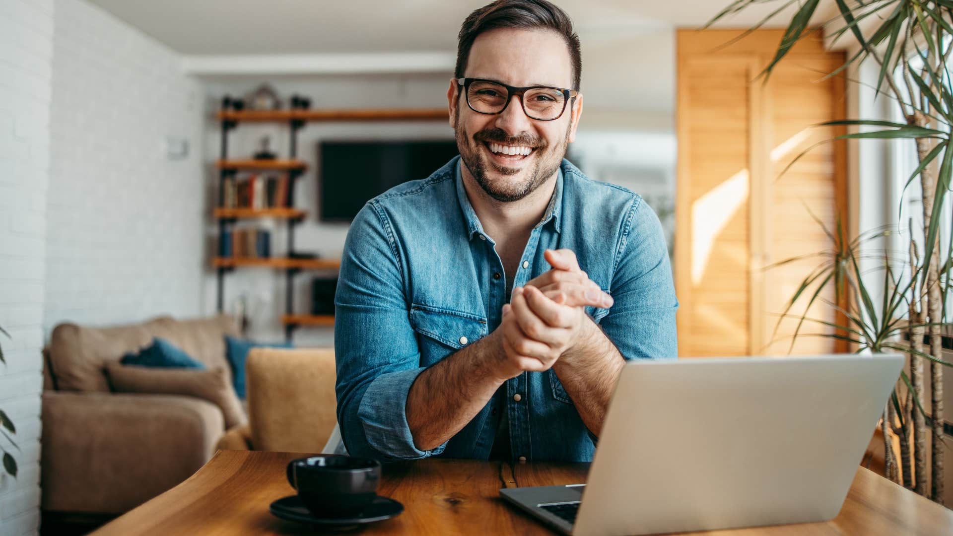 Man smiling sitting in front of his laptop.