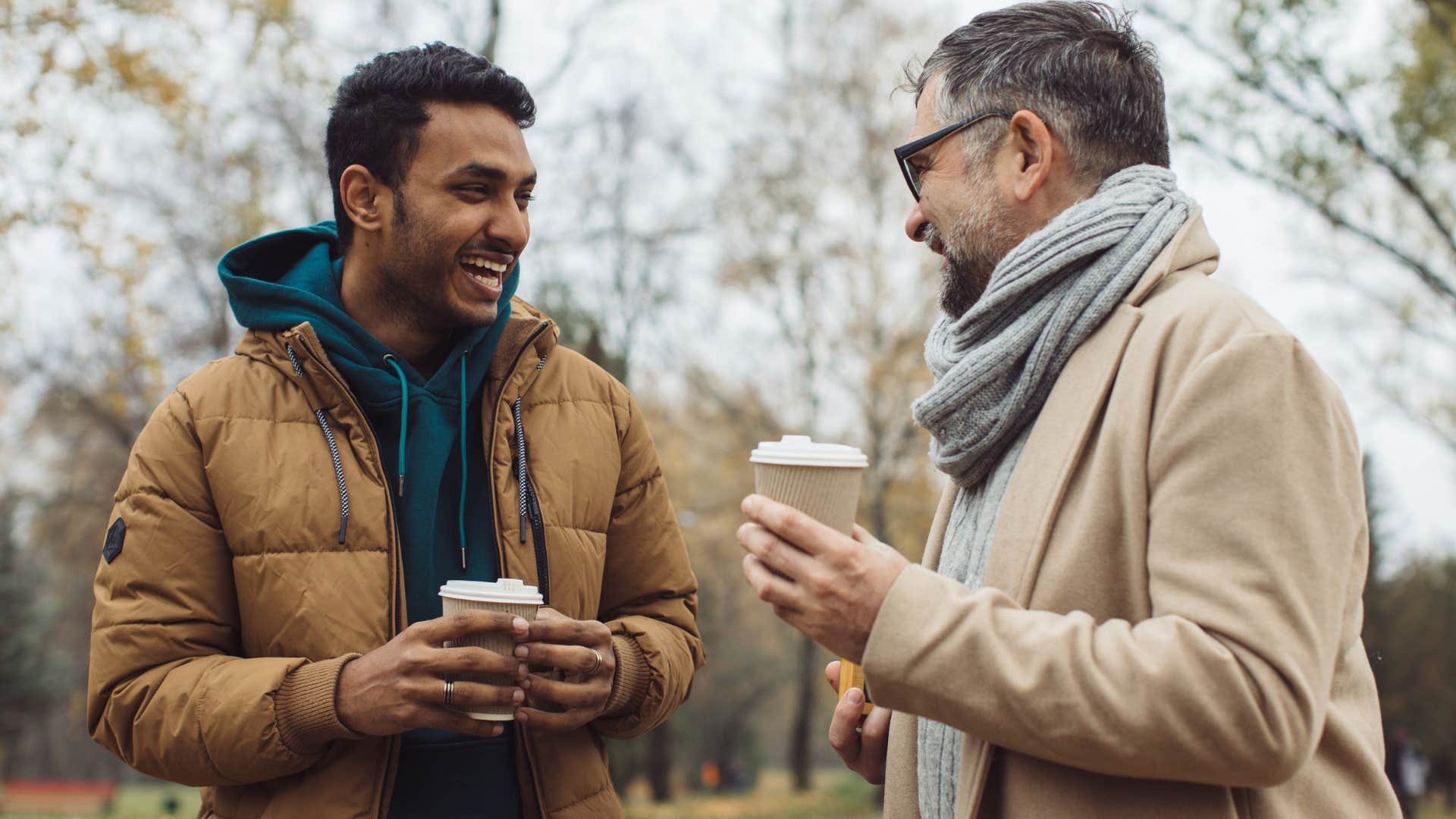 Two men smiling and talking to each other.