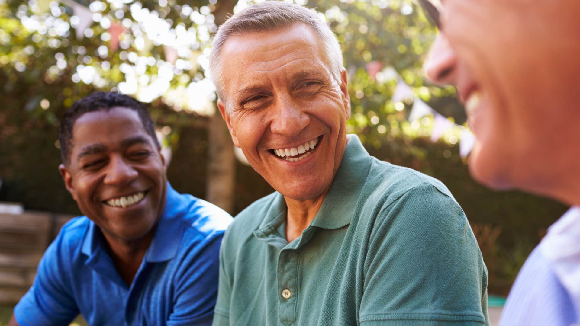 Older men smiling and talking together.