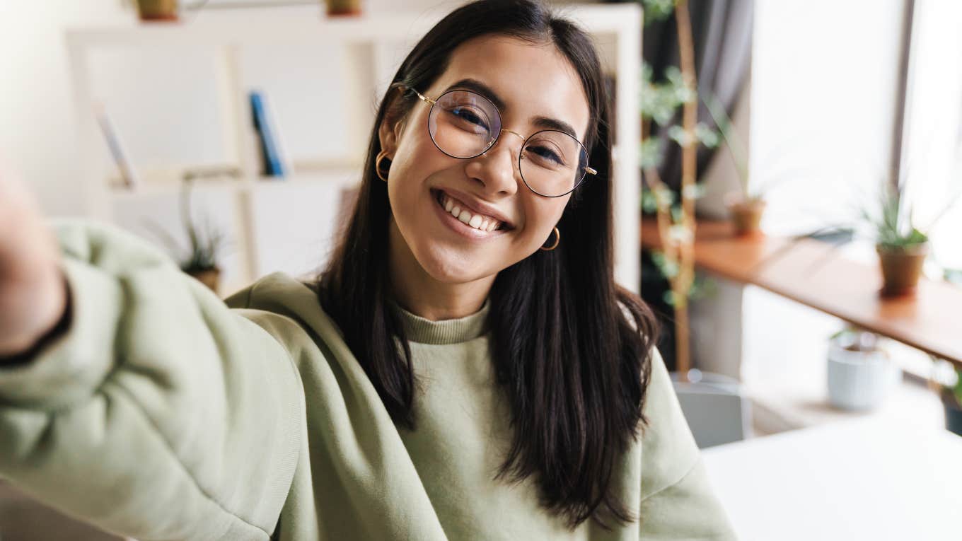 Young woman with glasses smiling at the camera