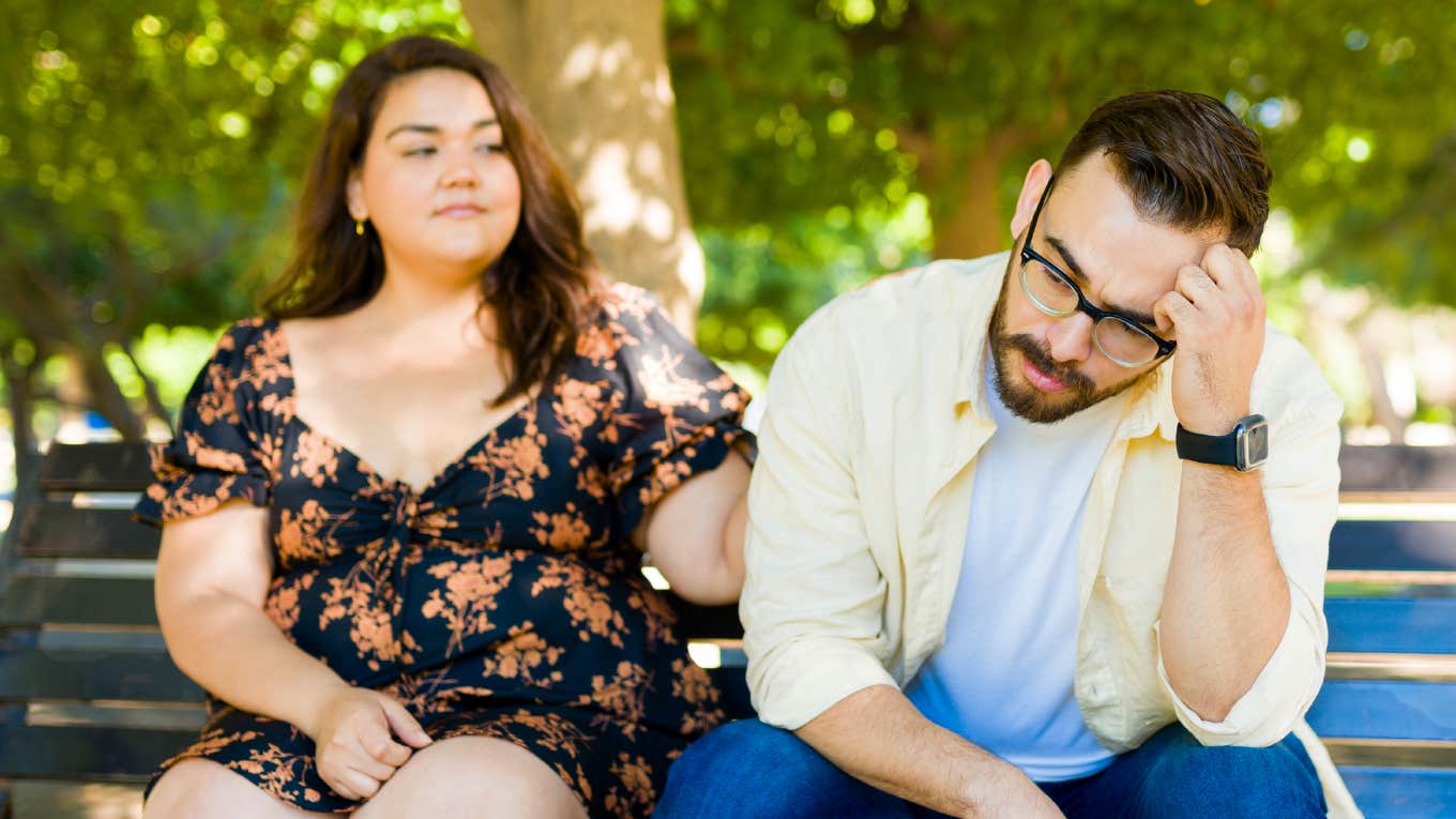 Couple lazily sitting on a bench.