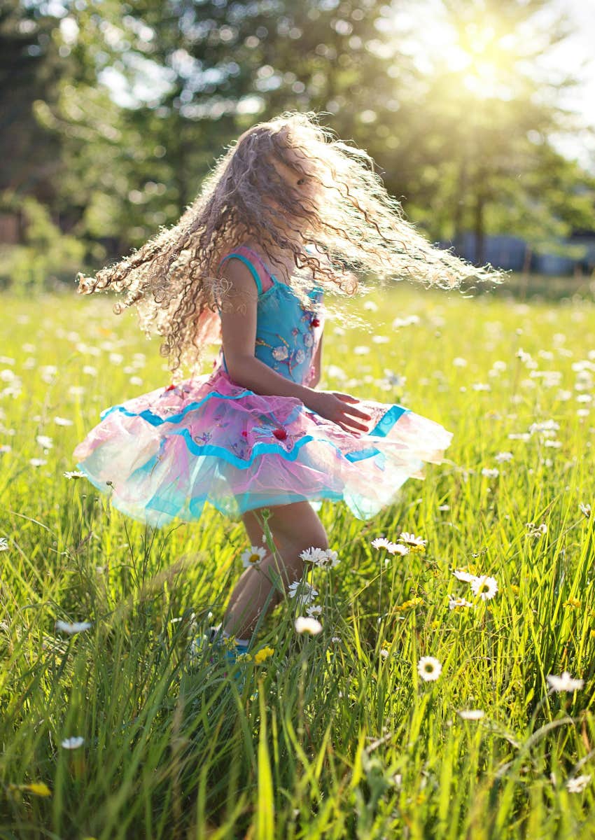 little girl dancing in a field of flowers