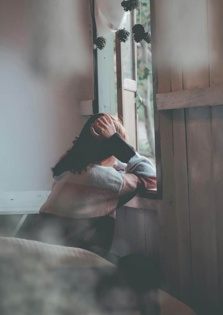 lonely woman looking out the window