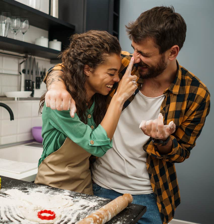 Playful couple in kitchen have soulmate connection