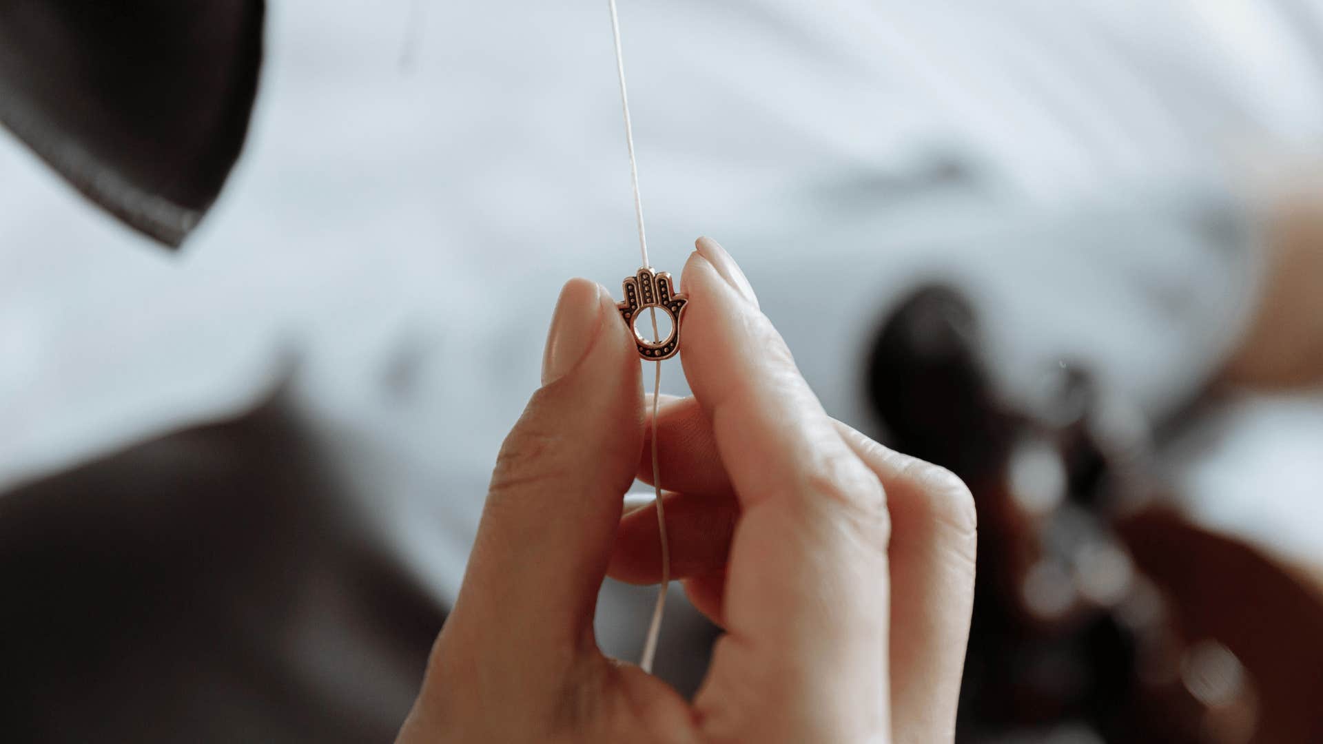 woman holding hamsa necklace