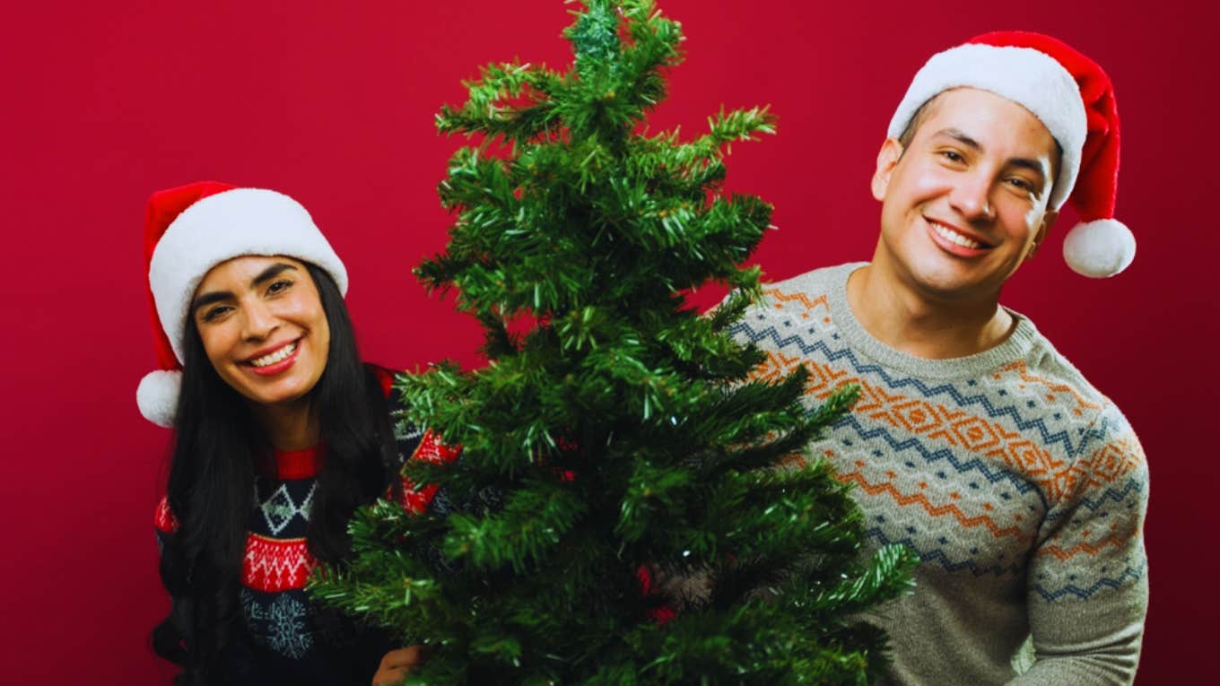 young happy couple with christmas tree 