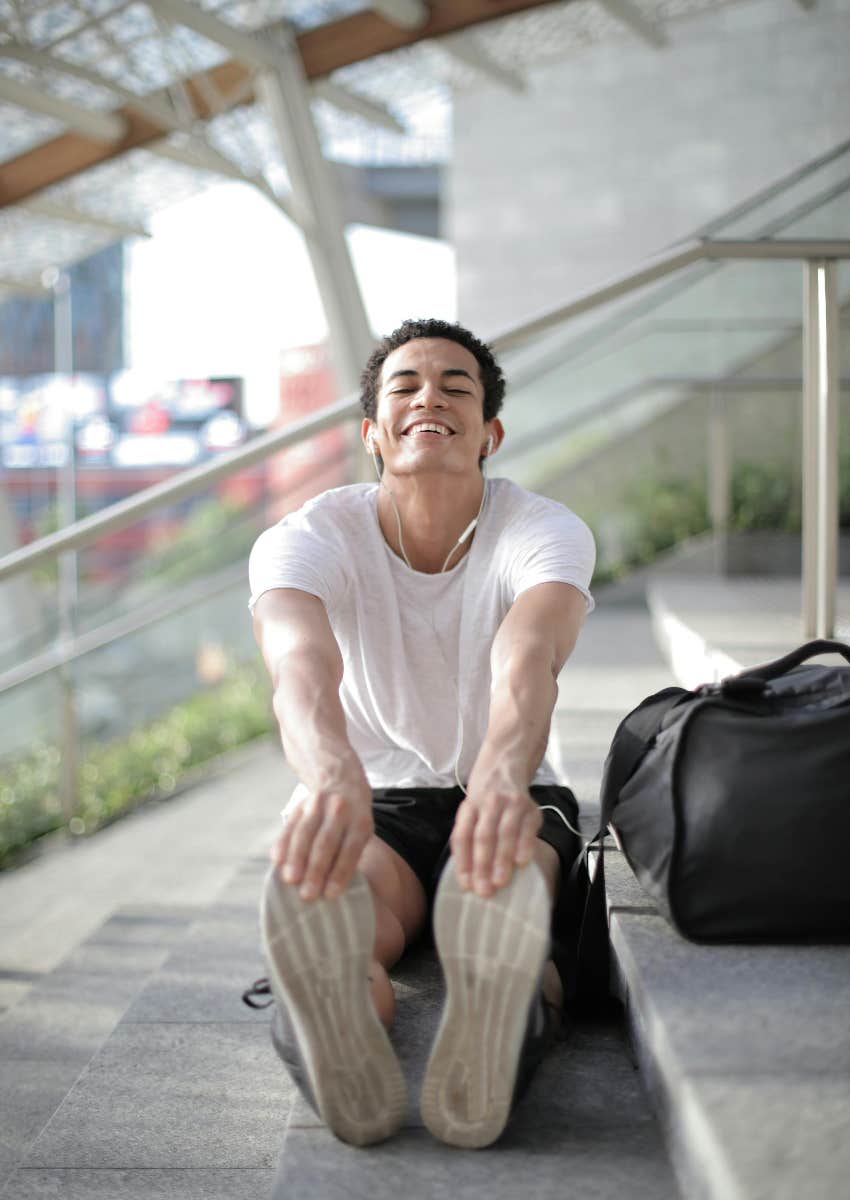 man stretching on stairs outside