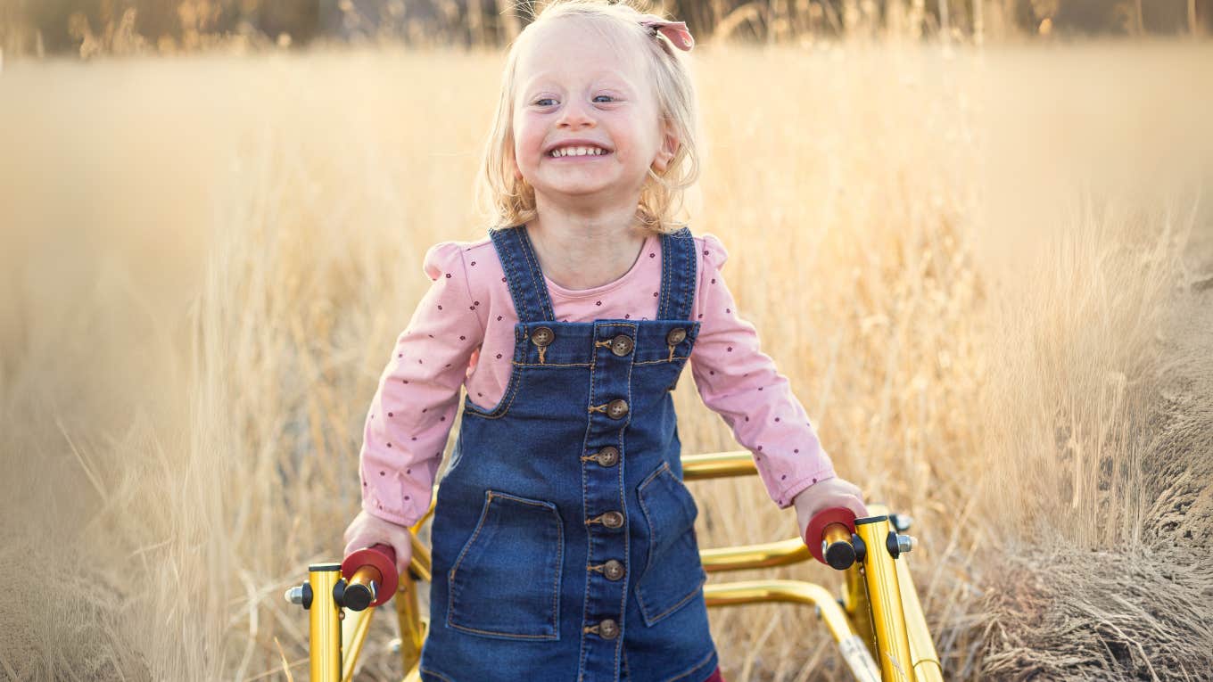 Smiling little girl using a walker