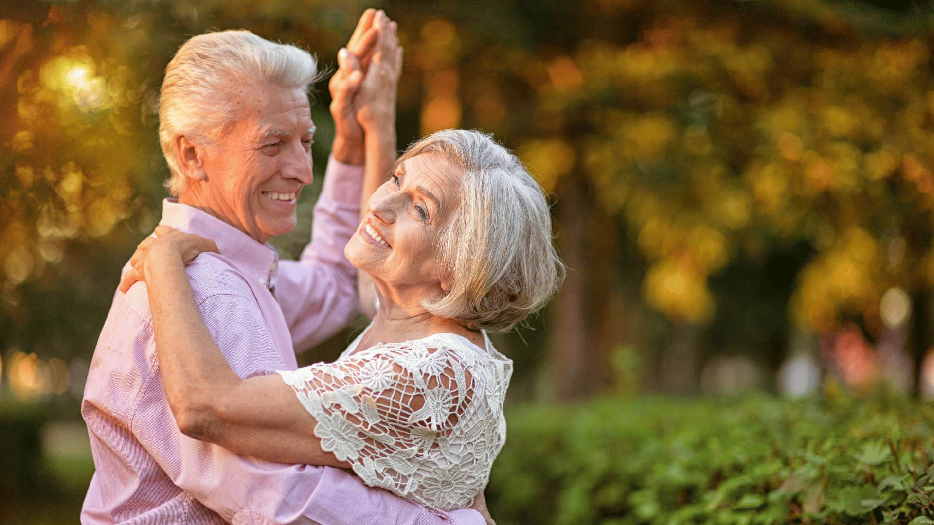 Happy Boomer couple smile while dancing