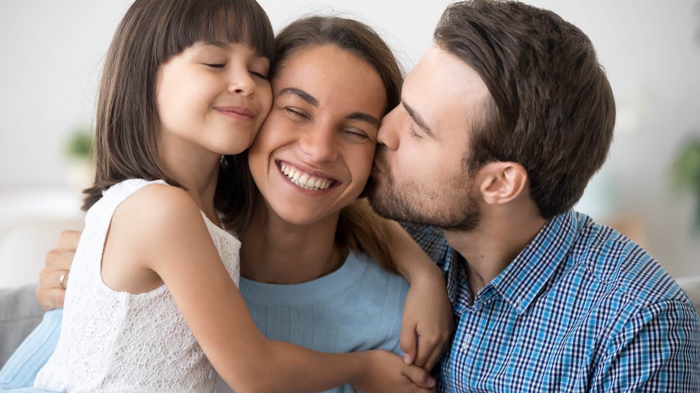 dad and daughter hugging and kissing mom