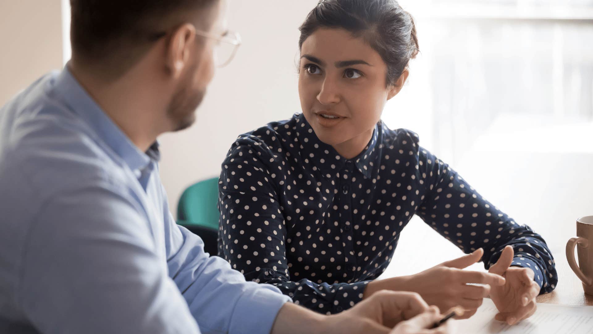 woman sitting next to and talking to man