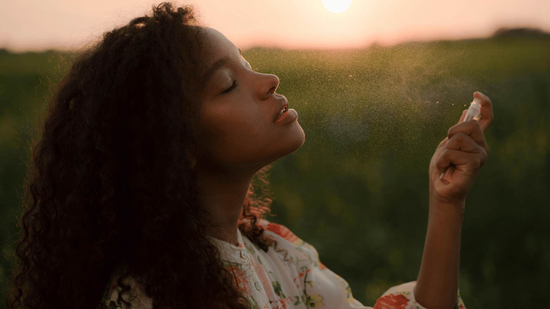 woman spraying on perfume