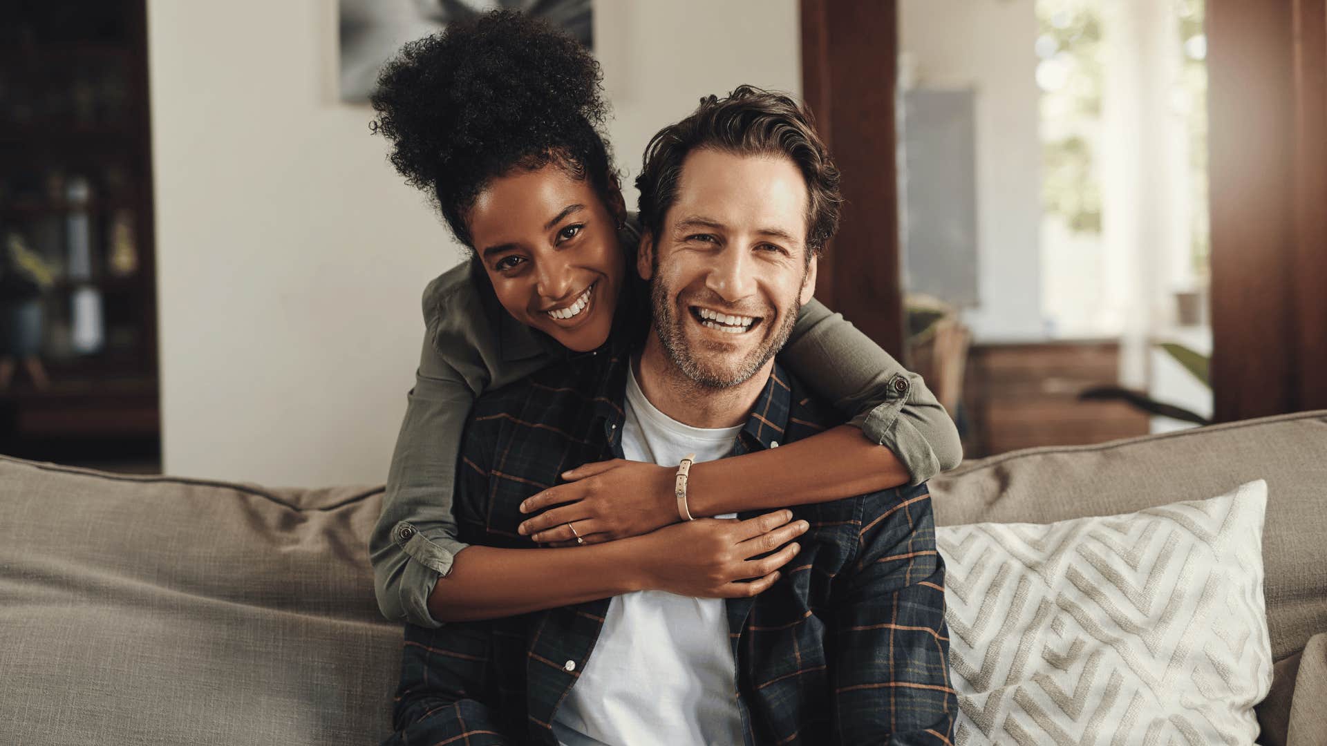 woman hugging man on couch