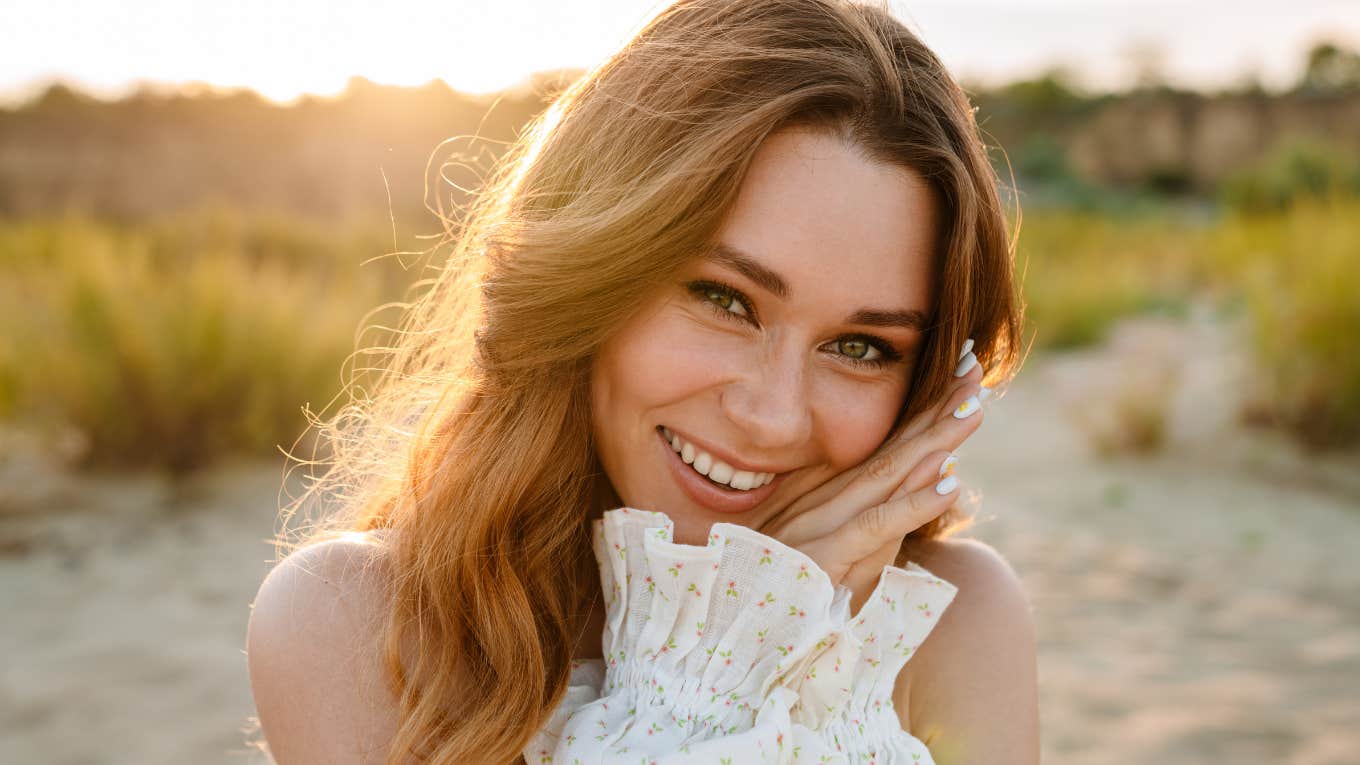 Brunette woman smiling and looking at camera outdoors