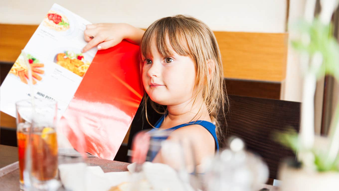 little girl pointing at what she wants on a restaurant menu