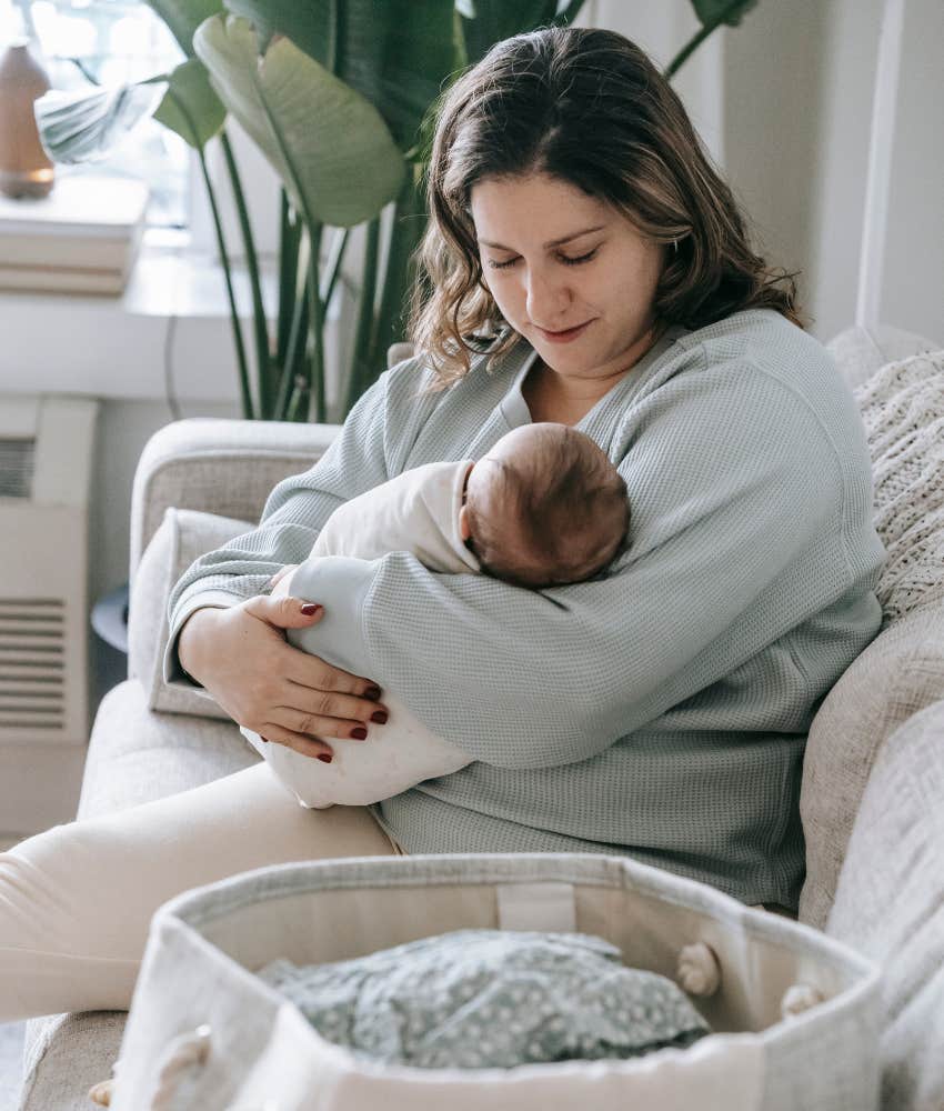 new mom with baby sitting on couch