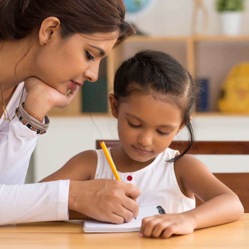 Mom helping her young daughter with her homework