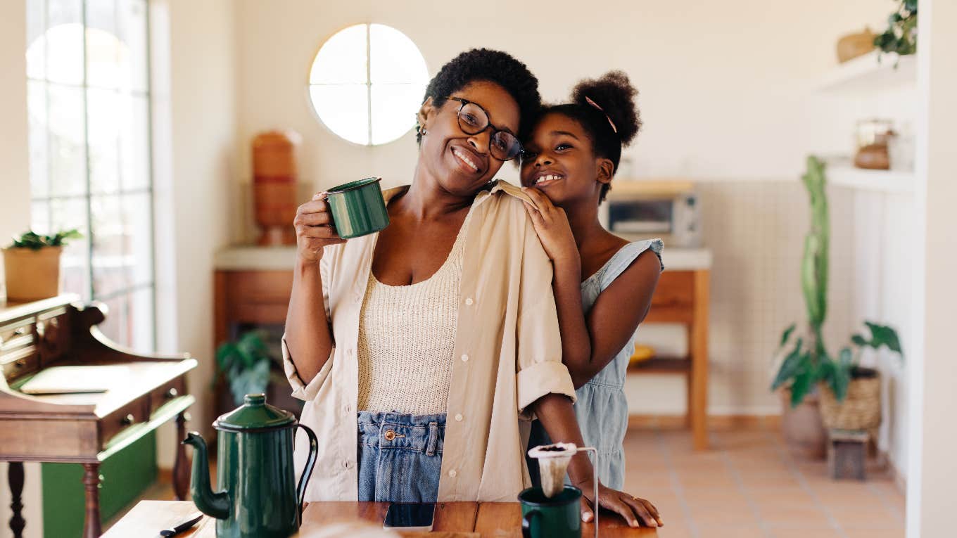 single mom with her daughter drinking coffee in the kitchen