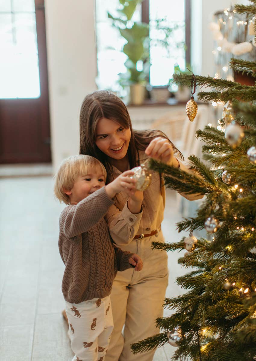 mom and son hanging ornaments on Christmas tree