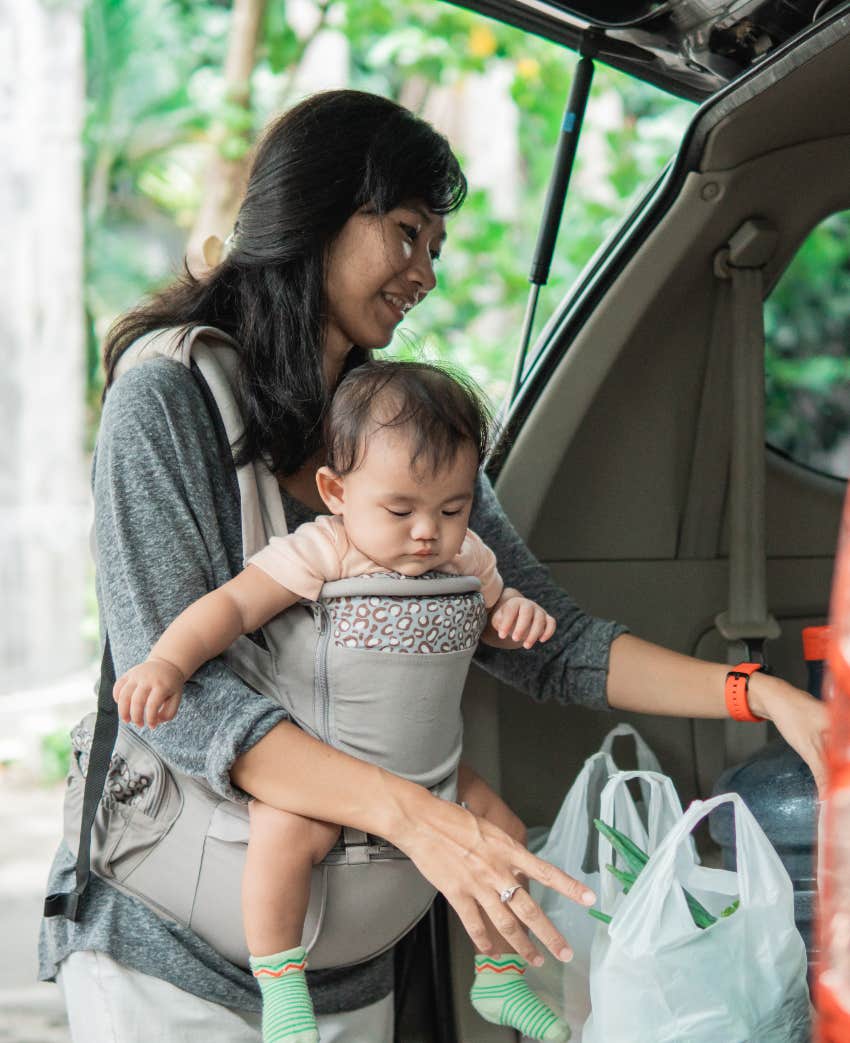 Single mom with hands full unloading groceries from her car