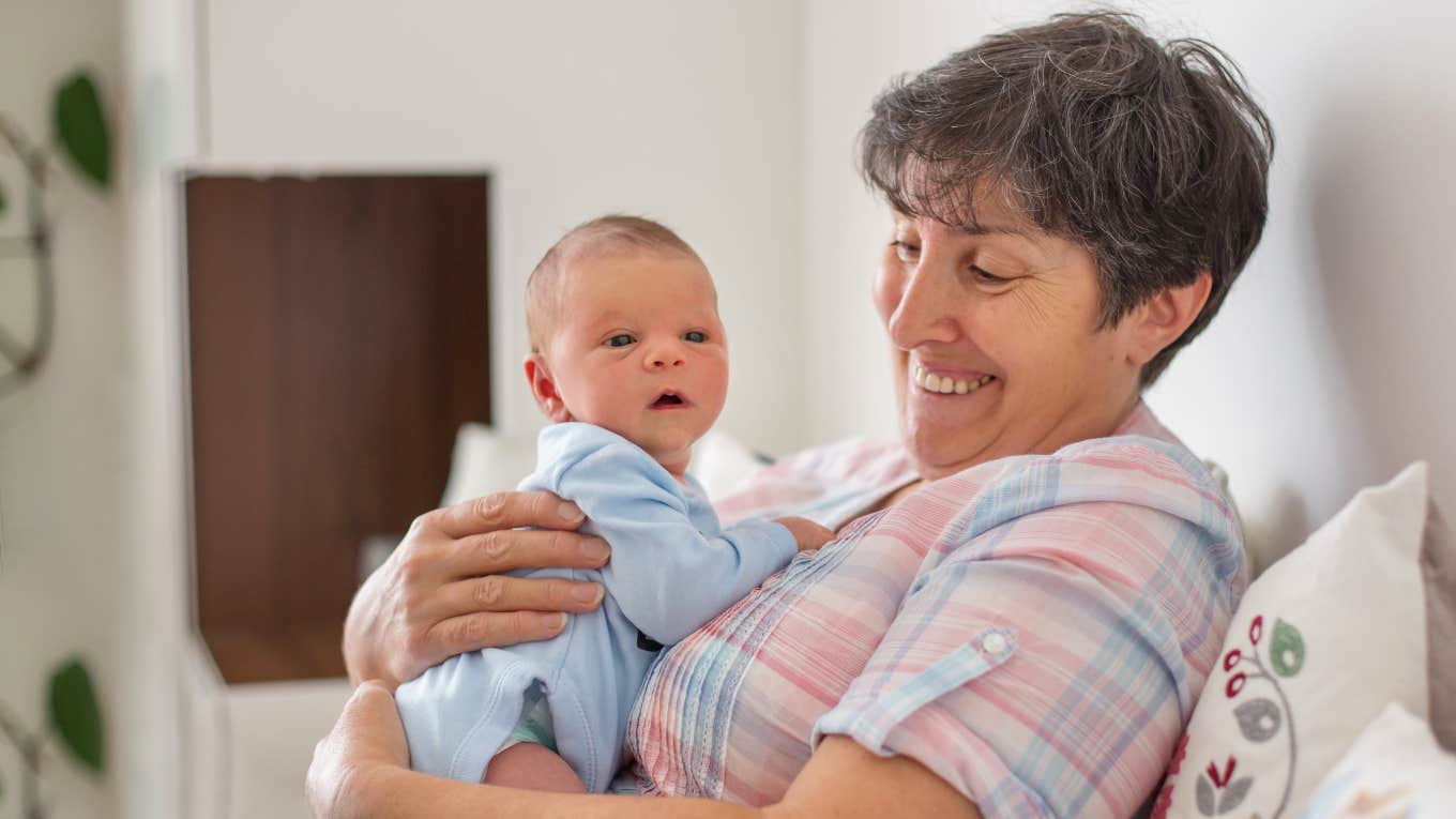 Mother-in-law holding newborn grandchild she woke up