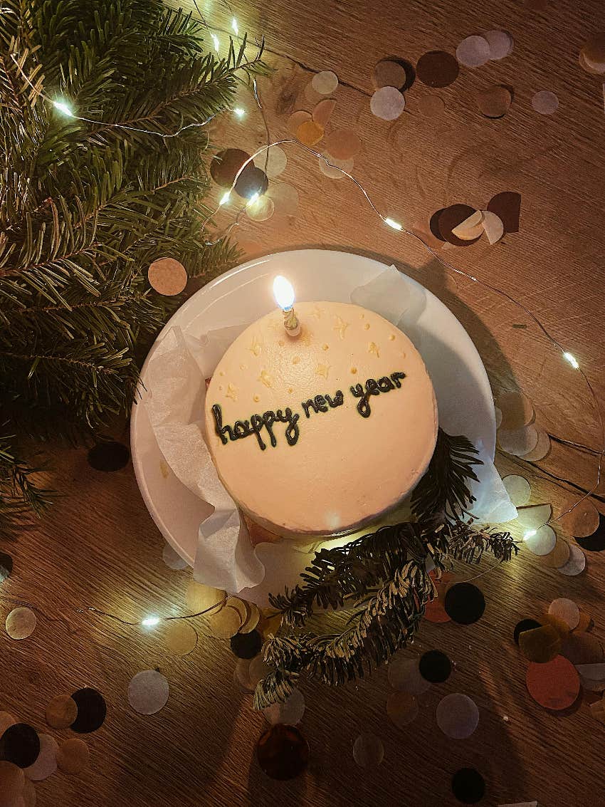 happy New Year cake on plate sitting on the floor with confetti